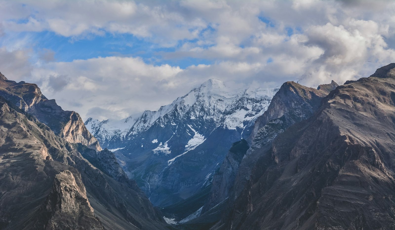 A snow peak above forest, representative of the trail toward Nanga Parbat base camp