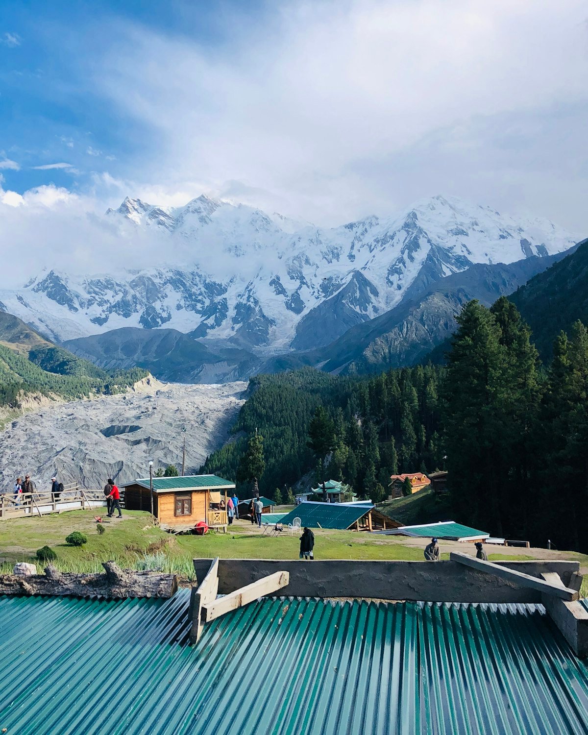 Nanga Parbat's snow face rising above the green meadow and forest of Fairy Meadows