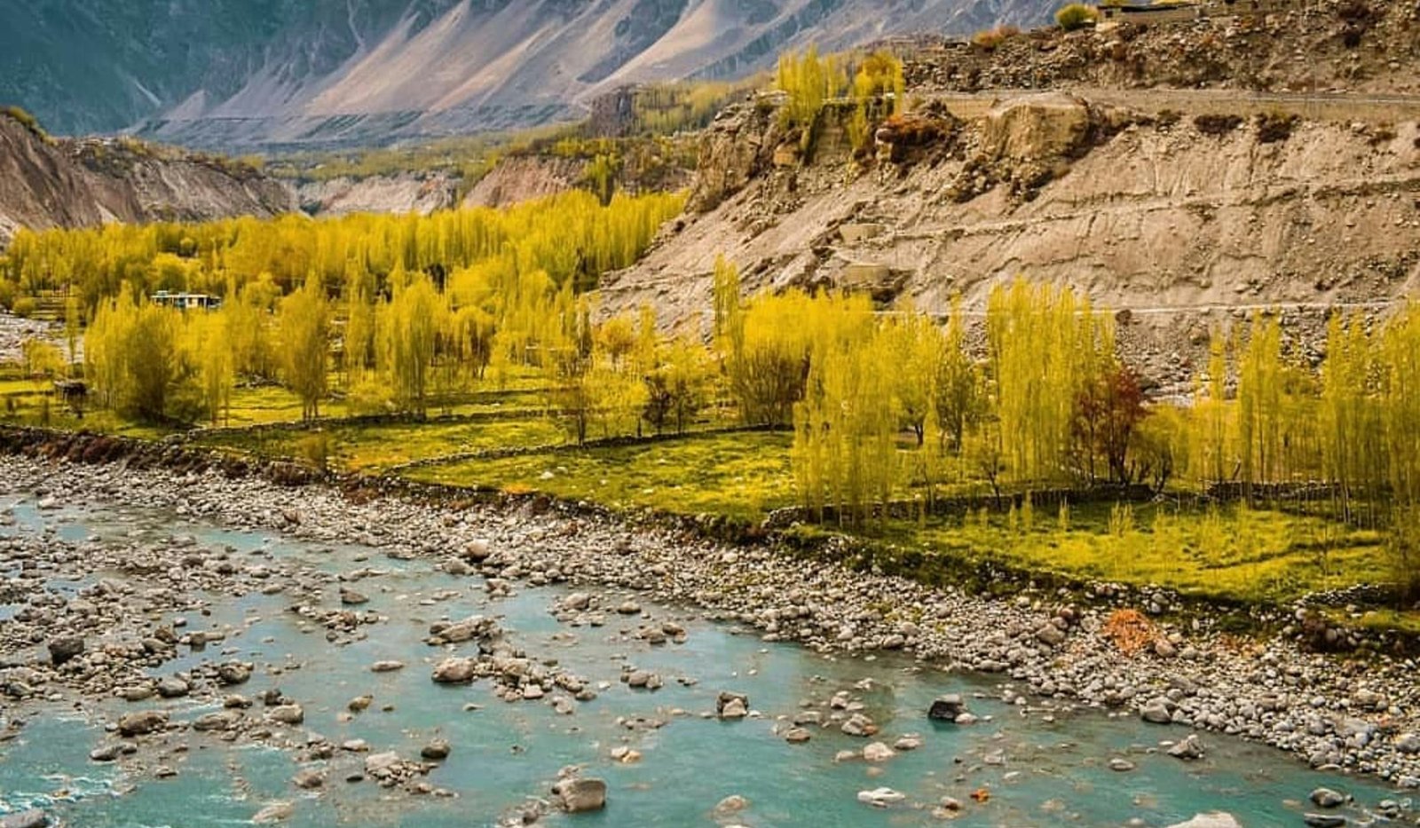 A turquoise river winding through an autumn valley in Ghizer