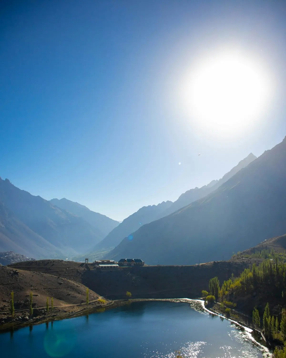 The turquoise water of Phander Lake among meadows and mountains in Ghizer